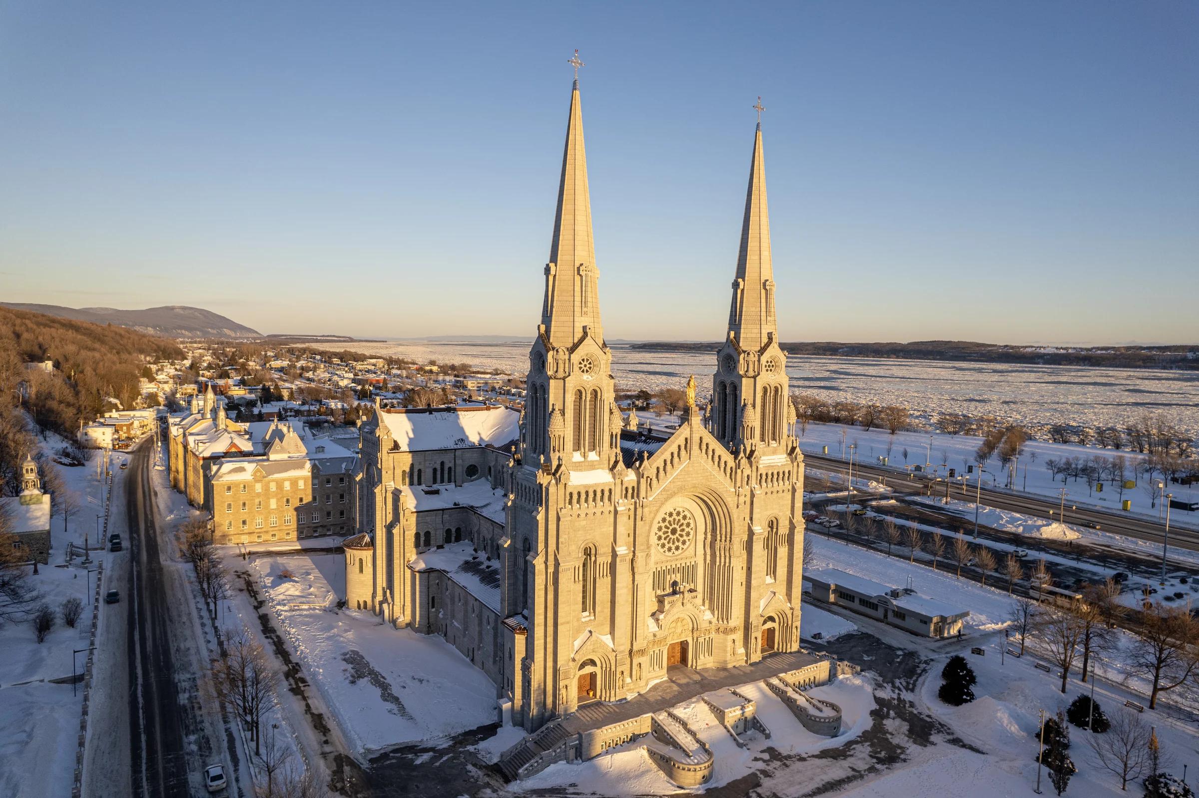 Winter aerial view of the Basilica of Sainte-Anne-de-Beaupré near the river.
